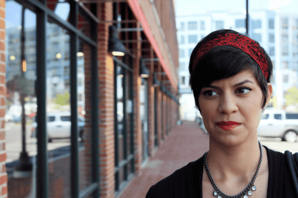 A person walking by a bank of windows in a building looks at the building wiht a skeptical look on their face